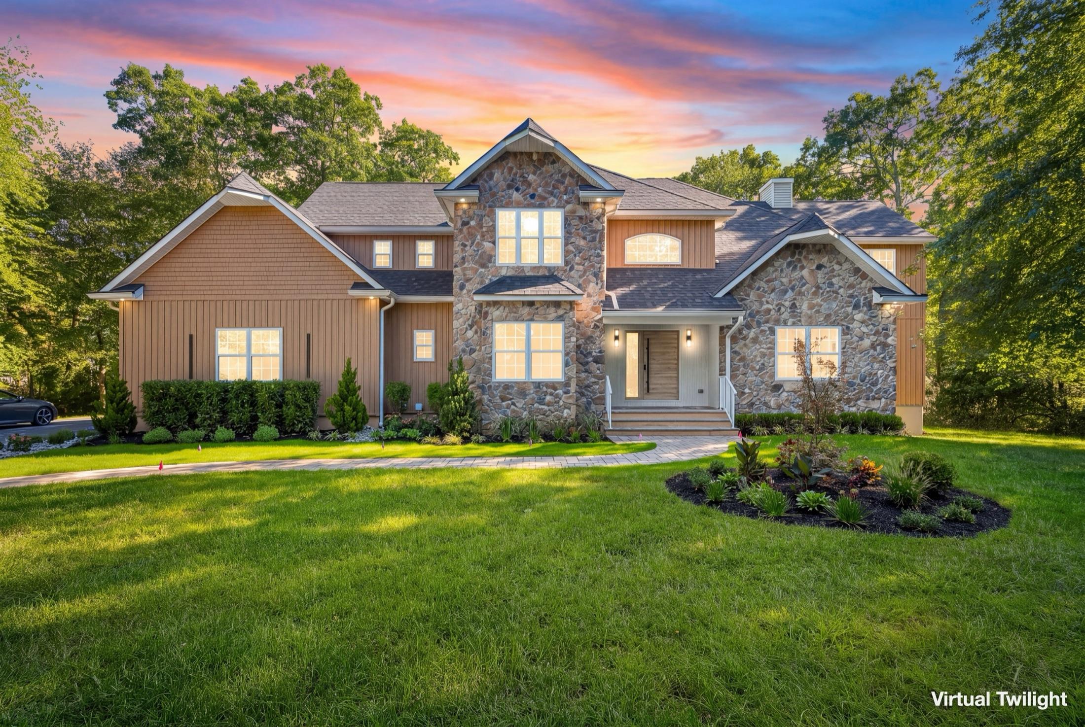Stone & cedar-shake colonial at virtual twilight with glowing windows and a dramatic dusk sky, NJ