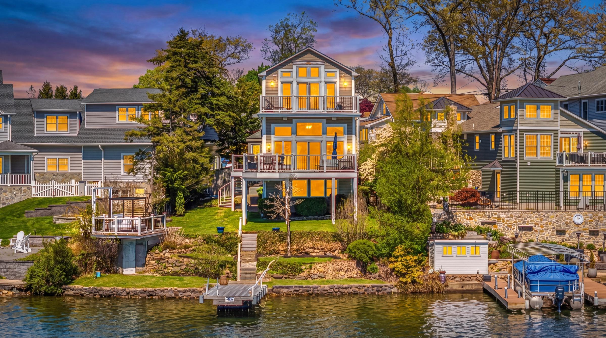 Stone-front home at sunset with a dramatic orange twilight sky