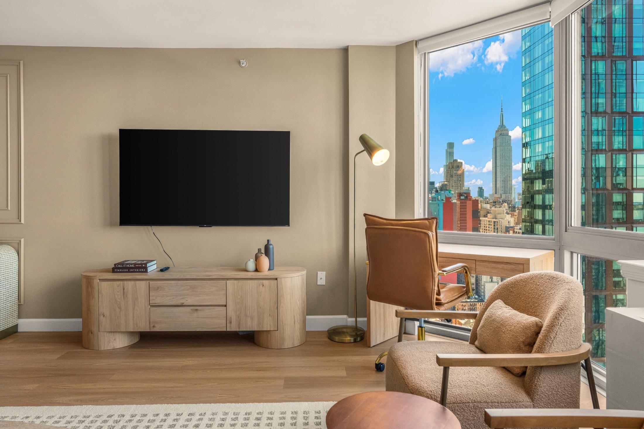 Short-term rental living room with an Empire State Building view through corner windows, Manhattan