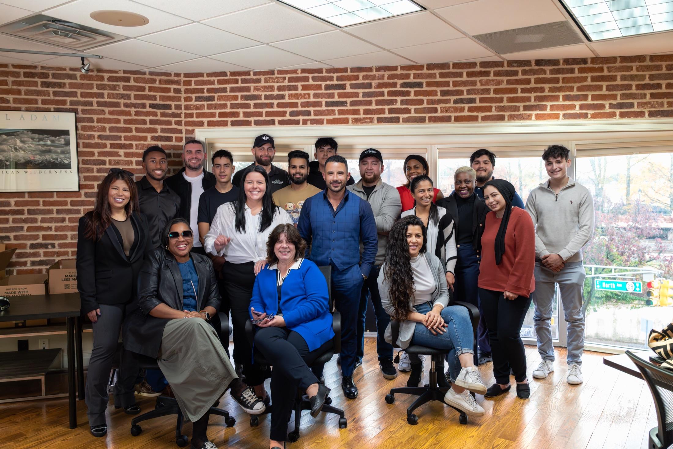 Real estate team group photo in their brick-walled NJ office